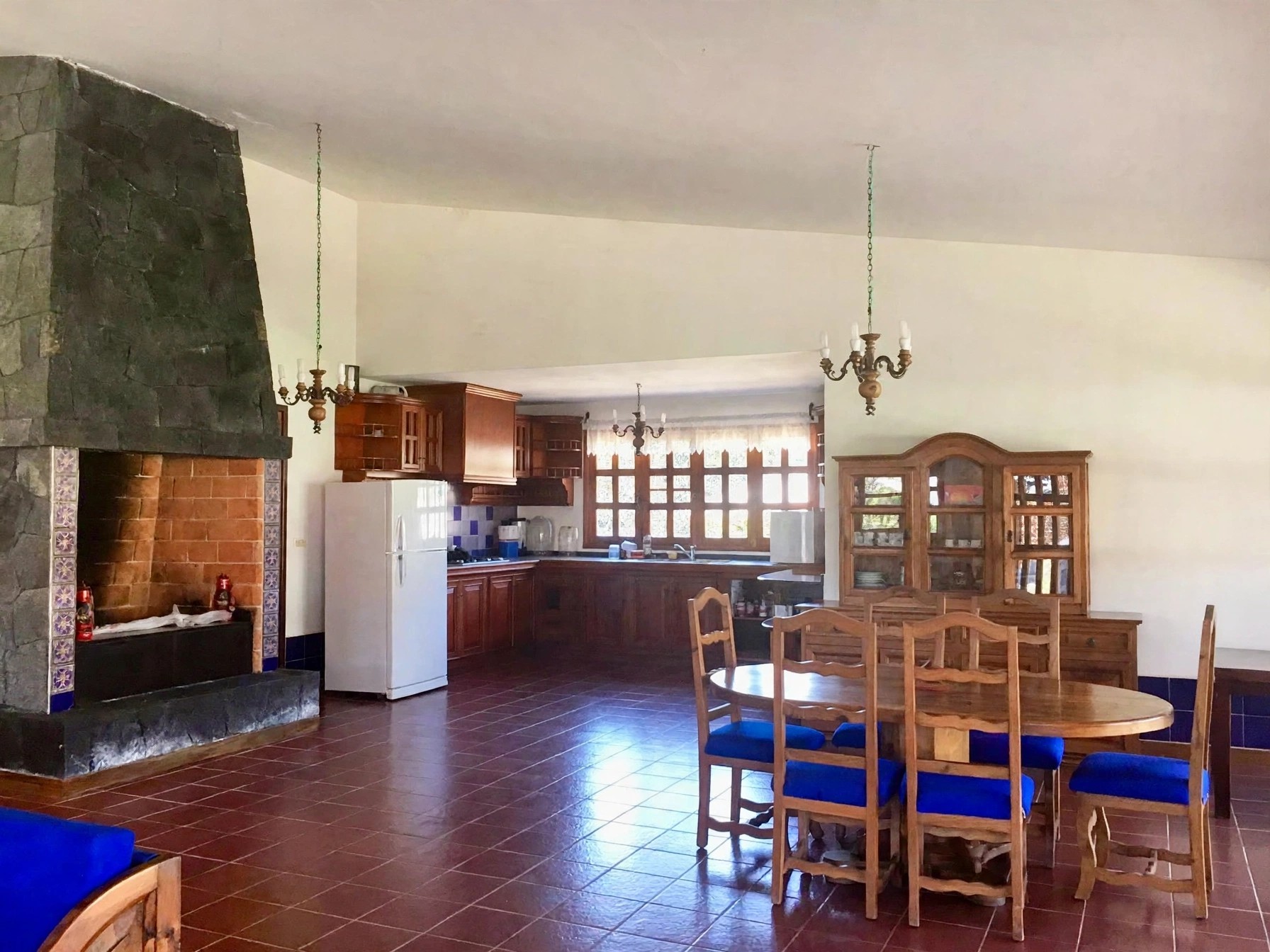Open-plan living, dining and kitchen with fireplace in the main house